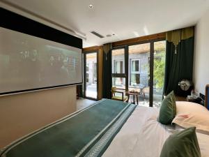 a bedroom with a large tv and a bed at Beijing Heyuan Courtyard Hotel (Forbidden City) in Beijing