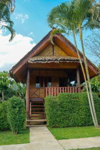 a resort with a palm tree and a house at Pai Homey in Pai