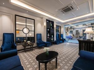 a living room with blue chairs and a table at The Flower Boutique Hotel & Travel in Hanoi