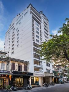 a tall white building on the side of a street at The Flower Boutique Hotel & Travel in Hanoi