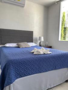 a blue bed with two towels on top of it at Hotel Boutique Los Pinos in Santa Rosa de Copán