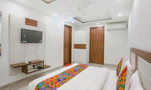 a bedroom with a bed and a tv on the wall at FabExpress Aerosky Boutique in New Delhi