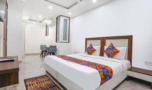 a bedroom with a large bed and a table and chairs at FabExpress Aerosky Boutique in New Delhi