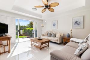 sala de estar con sofá y ventilador de techo en Paradise Links Resort Port Douglas, en Port Douglas