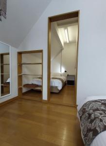 een slaapkamer met 2 bedden en een spiegel bij Miyuki Townhouse in Furano