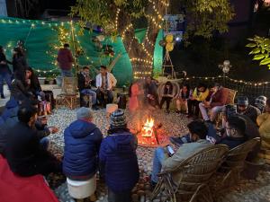 a group of people sitting around a fire at Soul Haven in Rishīkesh