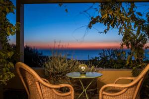 eine Terrasse mit einem Tisch und Stühlen sowie Meerblick in der Unterkunft Villa nonà Maria in Minia