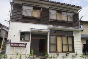 une maison blanche avec un panneau à l'avant dans l'établissement Annex higashifujita, à Moroyose