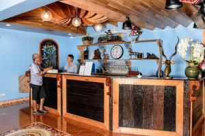 two people standing at a counter in a room at 2U Hotel Hatyai in Hat Yai