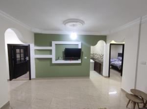 a living room with a tv on a green wall at noor apartment in Wadi Musa