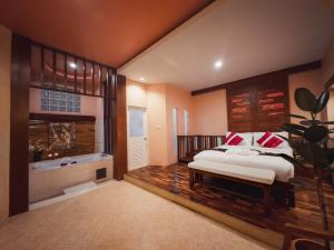 a bedroom with a bed and a tub in it at Suan Palm Garden View in Rayong