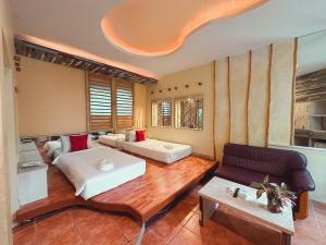 duży pokój z 2 łóżkami i kanapą w obiekcie Suan Palm Garden View w mieście Rayong