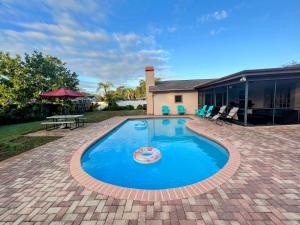 ein Schwimmbad in der Mitte eines Gartens in der Unterkunft Dream Vacation Home w Heated Pool Close to Beaches Clearwater St Pete Sleeps 14 in Seminole