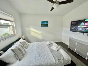 a bedroom with a bed and a flat screen tv at Dream Vacation Home w Heated Pool Close to Beaches Clearwater St Pete Sleeps 14 in Seminole