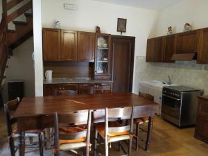 cocina con mesa de madera y algunas sillas en Canalicchio Apartment Strategic for visiting Umbria, en Canalicchio