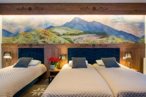 ザコパネにあるWilla Maria 4の壁に絵画が飾られた部屋のベッド2台
