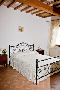 une chambre avec un lit dans une pièce blanche dans l'établissement Agriturismo Colle d' Oro, à Pescia Romana