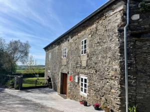 un antiguo edificio de piedra con una puerta y una puerta en Apartamento turístico rural Casa Chaín en Lugo