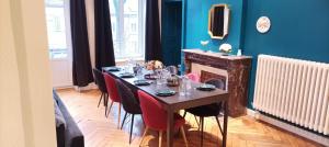 uma sala de jantar com uma mesa com cadeiras e uma lareira em Nouveau - Le Médicis - Centre em Sarrebourg