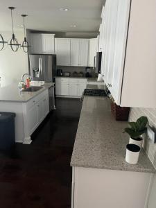 cocina con armarios blancos y suelo negro en Beautiful Home with Modern Rooms, en Round Rock