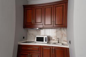a kitchen with a microwave and a sink at Mir Luxe Plaza in Tashkent