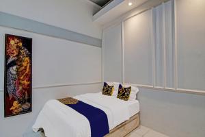 SPOT ON 92052 Aulya Homestay Syariah في Bangkinang: غرفة بيضاء مع سرير ونافذة