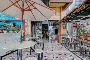 SPOT ON 92052 Aulya Homestay Syariah في Bangkinang: مطعم بطاولات وكراسي ومظلة
