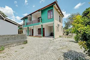 a house with a green and white building at OYO 92067 Sekar Gadung Homestay Syariah in Yogyakarta