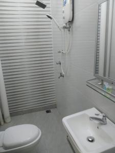 ein Bad mit einer Dusche, einem WC und einem Waschbecken in der Unterkunft Fikri Wetland Guesthouse & Resort 