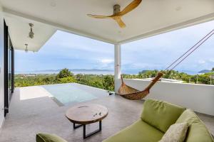 a living room with a hammock and a pool at Stunning SeaView Pool Villa in Haad Pleayleam
