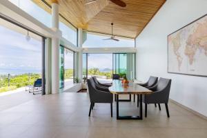 a dining room with a table and chairs at Stunning SeaView Pool Villa in Haad Pleayleam