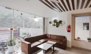 a living room with a couch and a table at FabHotel Amrit Grand in Gurgaon +22 photos