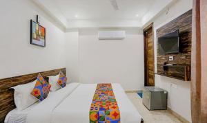 a bedroom with a large bed and a tv at FabHotel Amrit Grand in Gurgaon