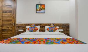 a bed with a colorful blanket on top of it at FabHotel Amrit Grand in Gurgaon