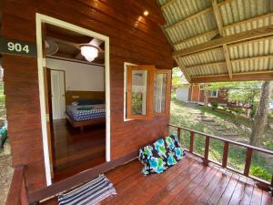 a porch of a wooden house with a bedroom at Mook Happy Bungalow in Ko Mook