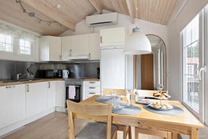 cocina con mesa de madera y comedor en First Camp Hökensås-Tidaholm en Tidaholm