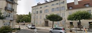 a street with cars parked in front of a building at Appartement studio Dole Grevy deux étoiles in Dole