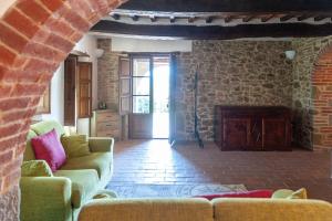 ein Wohnzimmer mit einem Sofa und einem Kamin in der Unterkunft Elm Tree, Olive Brench and Cypress Farmhouse Apartments With Pool - Happy Rentals in Panicale