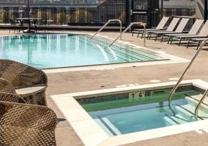 a large swimming pool with chairs and a table at Apart Hotel near Dodgers Stadium in Los Angeles