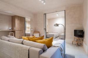 un soggiorno con un grande divano con cuscini gialli di Sofisticado apartamento en frente a la playa a Málaga