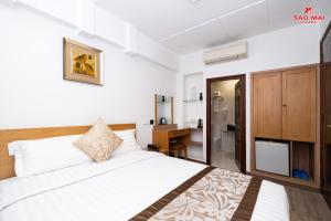 a bedroom with a large white bed and a bathroom at Sao Mai Hotel in Ho Chi Minh City