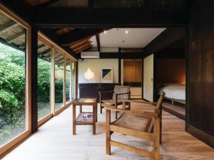 a room with a table and chairs and a bed at RITA Izumifumoto in Izumi