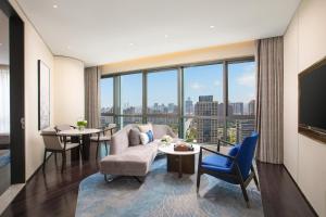 uma sala de estar com vista para a cidade em HUALUXE Shanghai Changfeng Park, an IHG Hotel em Xangai