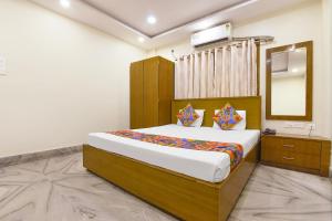 a bedroom with a large bed and a mirror at FabHotel The Eden Ruby in Kolkata