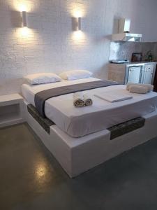 a large white bed with two towels on it at Traditional house under the castle in Astypalaia Town