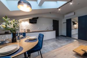 a kitchen and dining room with a wooden table and blue chairs at MILU Apartments Sebastiana in Kraków +34 photos