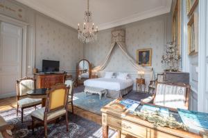 - une chambre avec un lit, une table et des chaises dans l'établissement L'Hotel de Panette, Un exceptionnel château en ville, à Bourges