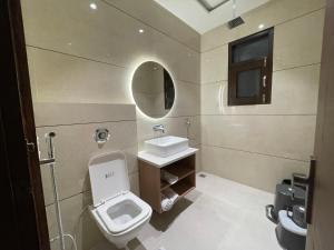a bathroom with a toilet and a sink and a mirror at Hotel Crown Savoy, Near Railway Station & GURU NANAK DEV UNIVERSITY in Amritsar