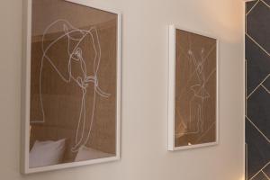 duas pinturas emolduradas de um cavalo numa parede em MILU Apartments Sebastiana em Cracóvia