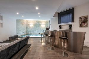 uma sala de estar com piscina e um bar com bancos em Design Apartment with private pool exclusive use - Stelvio 21 em Milão